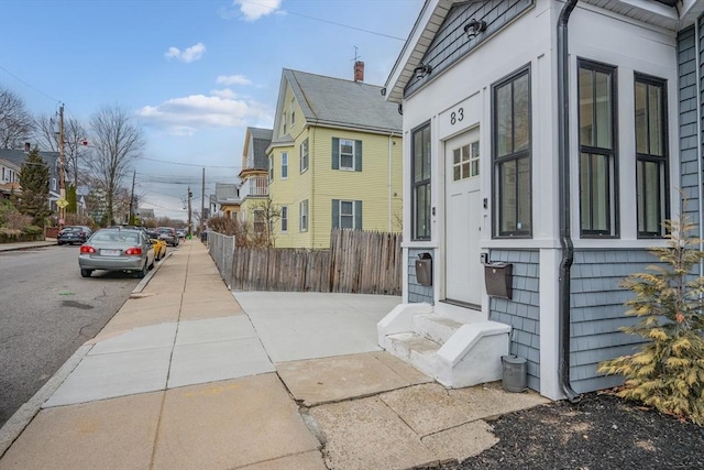 view of side of home with entry steps and fence