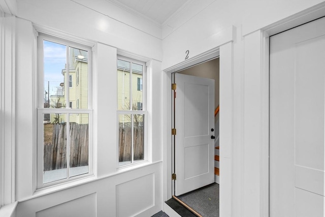 doorway featuring ornamental molding and a healthy amount of sunlight