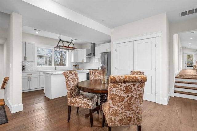 dining room featuring stairway, wood-type flooring, visible vents, and recessed lighting