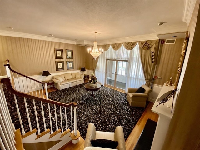 carpeted living area with stairway, a notable chandelier, visible vents, and crown molding