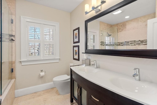 bathroom with a sink, baseboards, toilet, and double vanity