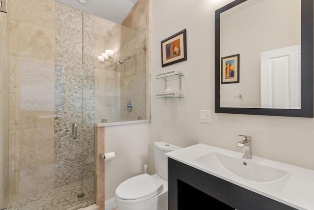 bathroom featuring toilet, a stall shower, and vanity