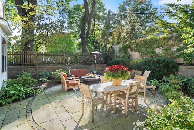 view of patio / terrace featuring outdoor dining area, a fenced backyard, and an outdoor fire pit