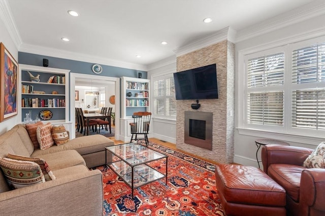 living room featuring recessed lighting, crown molding, a large fireplace, and wood finished floors