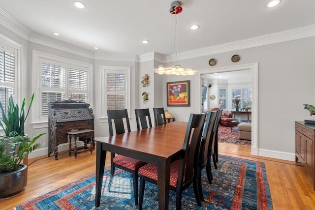 dining area with a wealth of natural light, light wood-style flooring, and ornamental molding