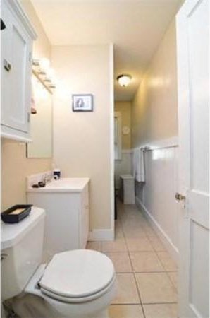 bathroom with toilet, tile patterned flooring, and vanity