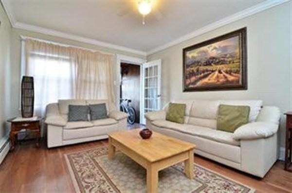 living area with crown molding and wood finished floors