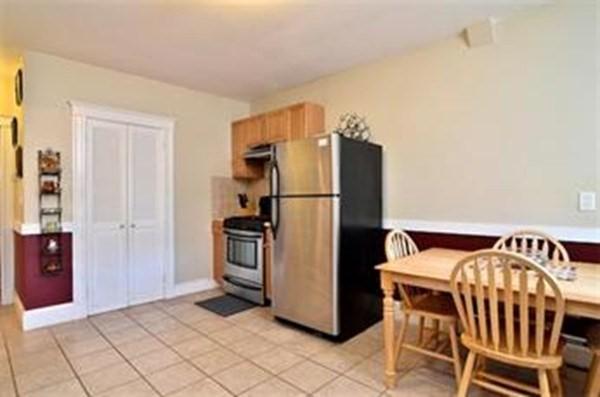 kitchen featuring a wood stove, light tile patterned flooring, and stainless steel appliances
