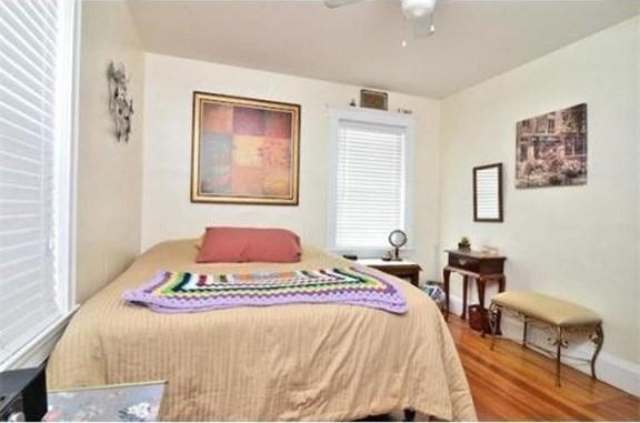 bedroom featuring baseboards, ceiling fan, and wood finished floors