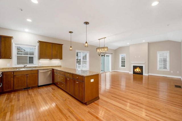 kitchen featuring kitchen peninsula, sink, pendant lighting, dishwasher, and light hardwood / wood-style floors