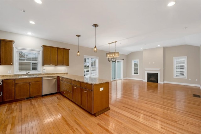 kitchen featuring dishwasher, light hardwood / wood-style floors, sink, and hanging light fixtures