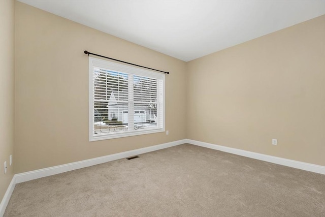 unfurnished room featuring light carpet