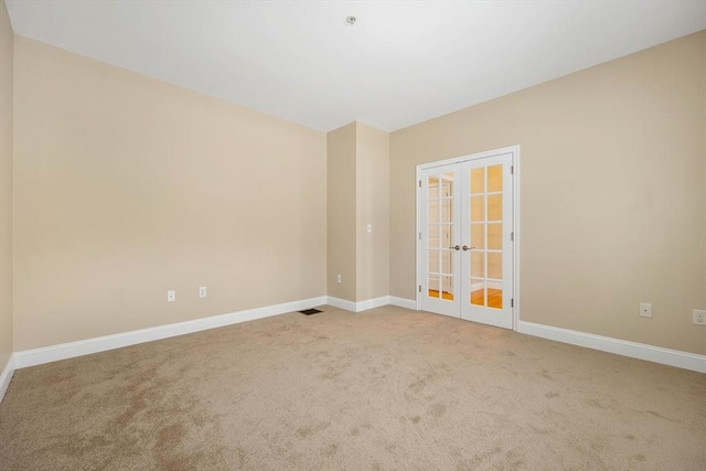 spare room featuring french doors and carpet floors