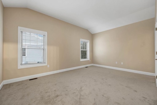 unfurnished room featuring carpet floors and vaulted ceiling