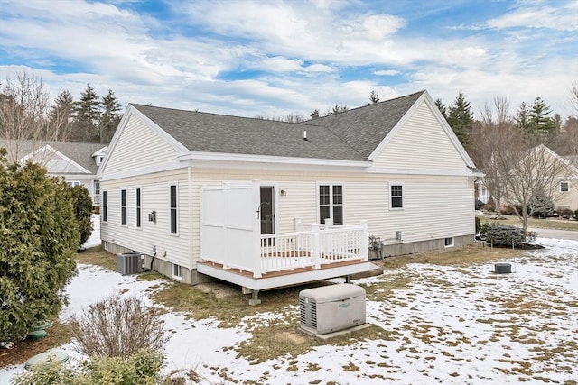 snow covered property featuring central AC and a deck