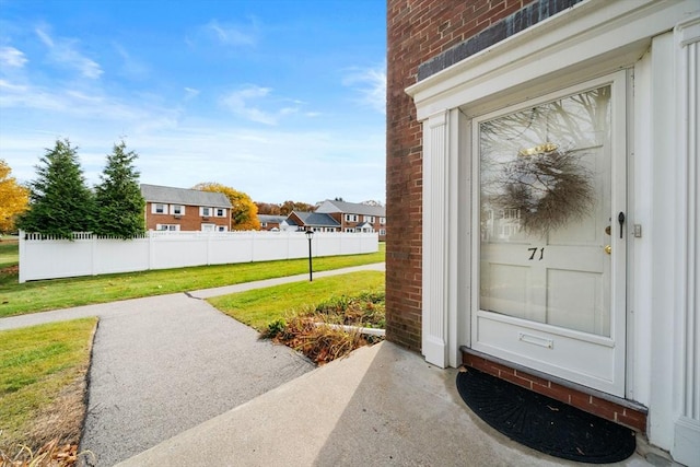 doorway to property featuring a lawn