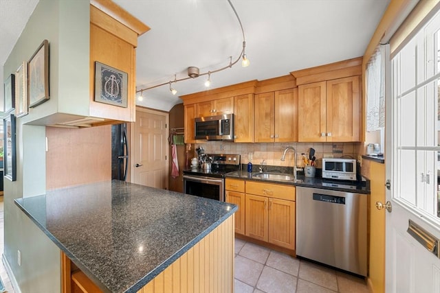 kitchen featuring appliances with stainless steel finishes, sink, backsplash, plenty of natural light, and light tile patterned flooring