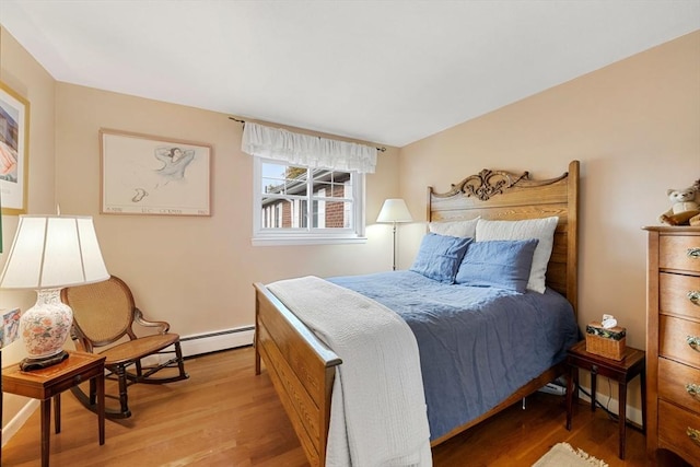 bedroom with wood-type flooring and a baseboard radiator