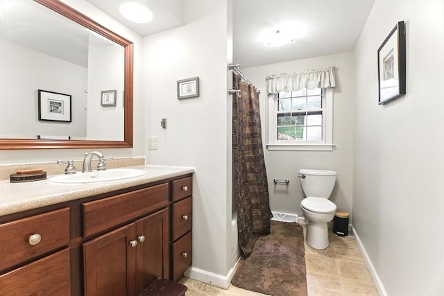 bathroom featuring toilet, vanity, baseboards, and tile patterned flooring