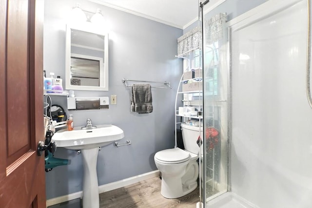 full bathroom with a shower stall, ornamental molding, wood finished floors, toilet, and baseboards