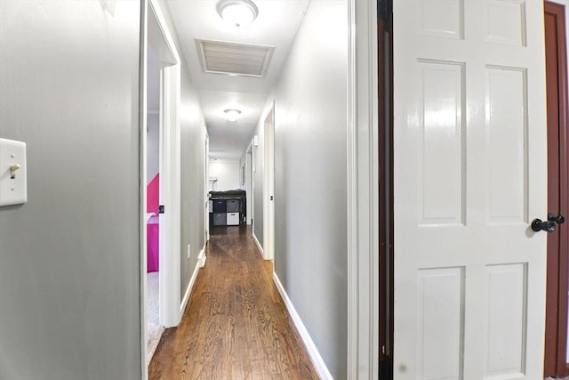 hall with wood finished floors, attic access, and baseboards