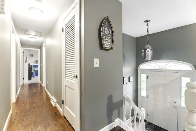 entrance foyer with dark wood finished floors, baseboards, and healthy amount of natural light