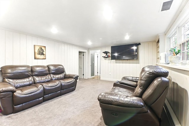 carpeted living room featuring wooden walls