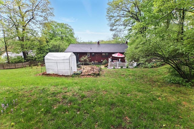 rear view of property featuring an exterior structure, an outdoor structure, and a chimney