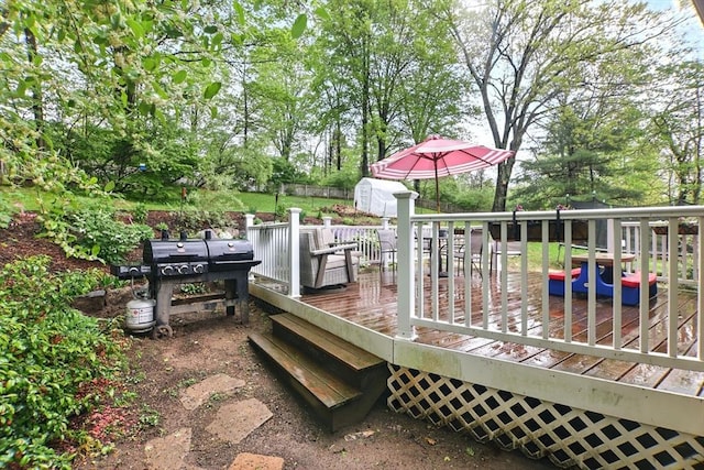wooden deck with a shed, grilling area, an outdoor structure, and view of wooded area