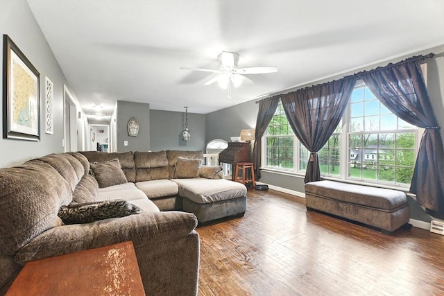 living room featuring wood finished floors, ceiling fan, and baseboards