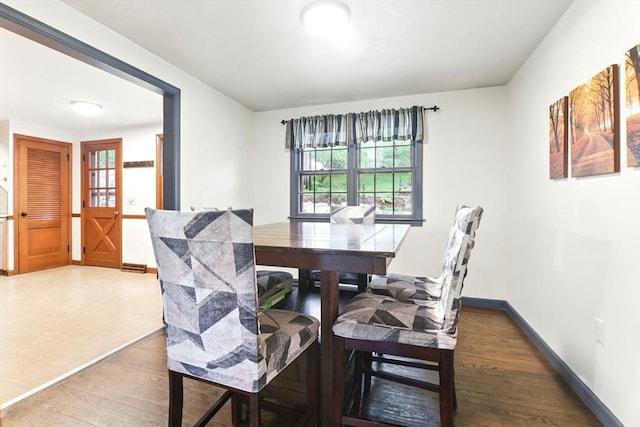 dining room featuring wood finished floors and baseboards