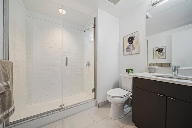 bathroom featuring tile patterned flooring, vanity, toilet, and walk in shower