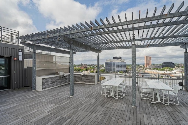 wooden deck with a pergola and an outdoor kitchen