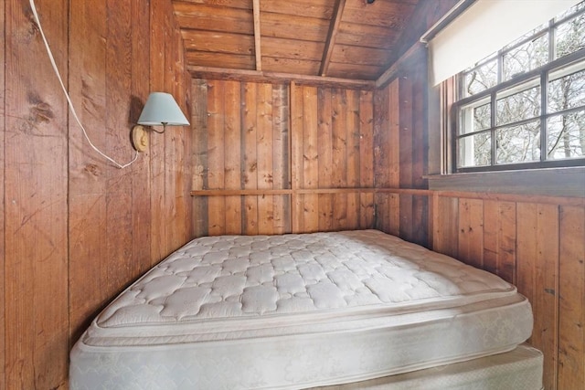 unfurnished bedroom with lofted ceiling with beams, wood walls, and wood ceiling