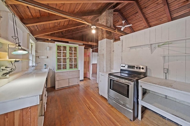 kitchen with electric stove, light countertops, hanging light fixtures, and white cabinetry