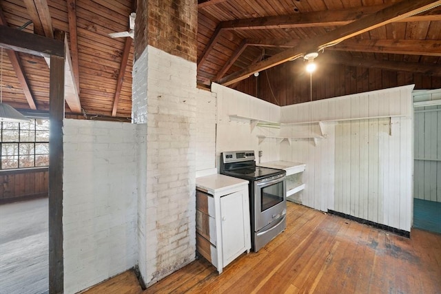 kitchen with light countertops, lofted ceiling with beams, wood ceiling, stainless steel range with electric stovetop, and light wood-type flooring