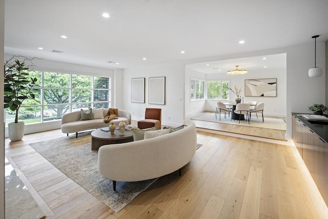 living room with plenty of natural light, recessed lighting, light wood finished floors, and baseboards