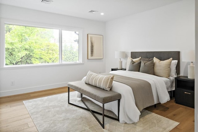 bedroom with wood finished floors, baseboards, and recessed lighting