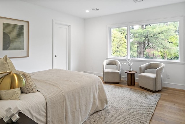 bedroom with wood finished floors, baseboards, and recessed lighting