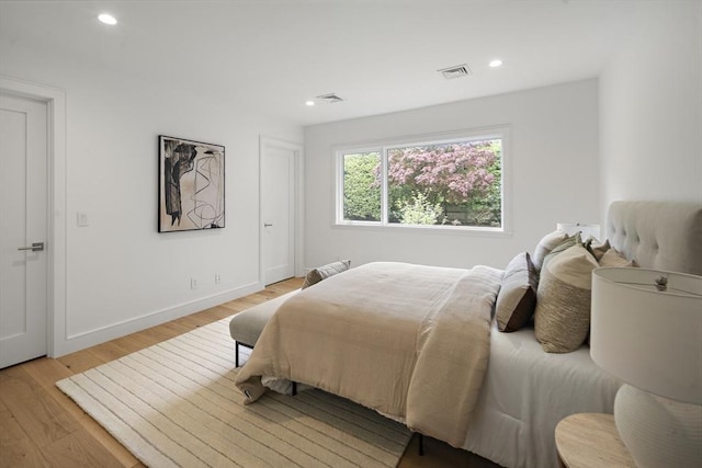 bedroom with light wood finished floors, recessed lighting, and baseboards