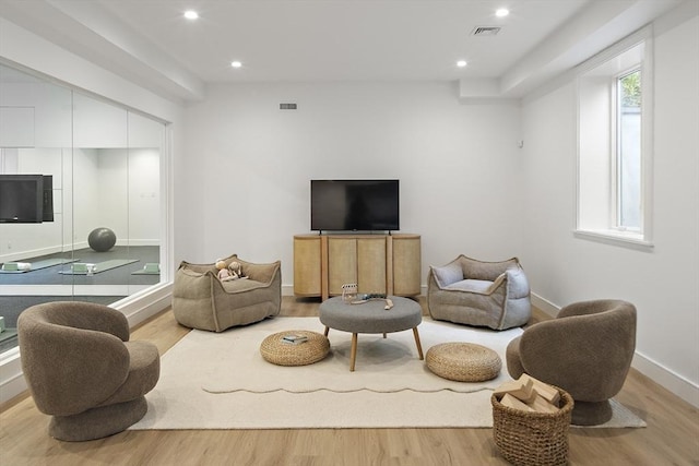 living area featuring wood finished floors, baseboards, and recessed lighting