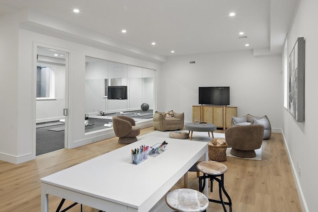 living area with recessed lighting, light wood finished floors, and baseboards