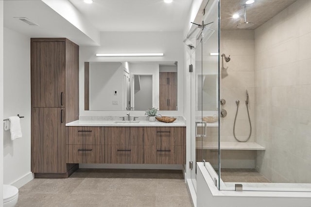 full bath featuring a shower stall, vanity, baseboards, and toilet
