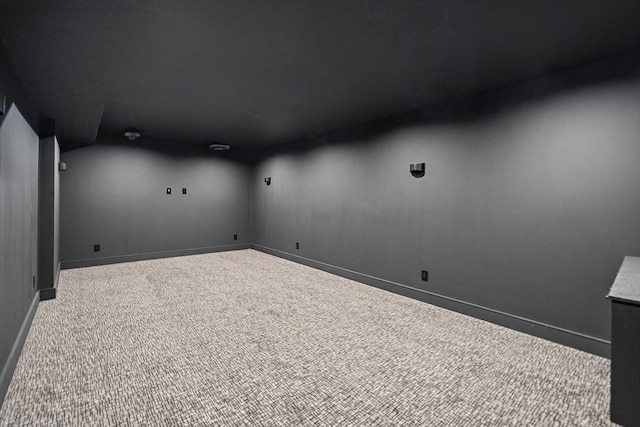 empty room with carpet, lofted ceiling, and baseboards