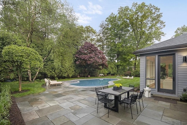 swimming pool featuring a patio, outdoor dining space, and a lawn