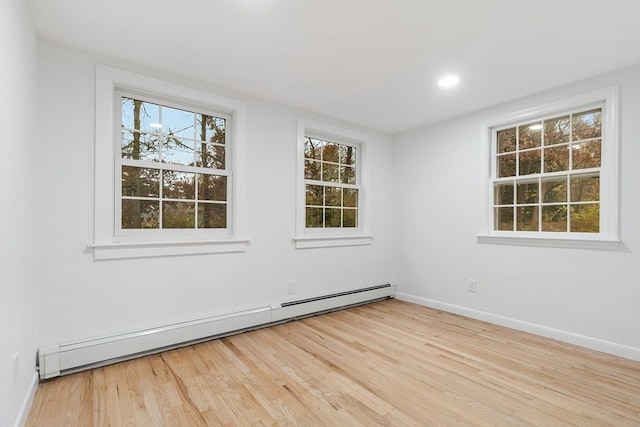 spare room with light hardwood / wood-style floors and a baseboard heating unit