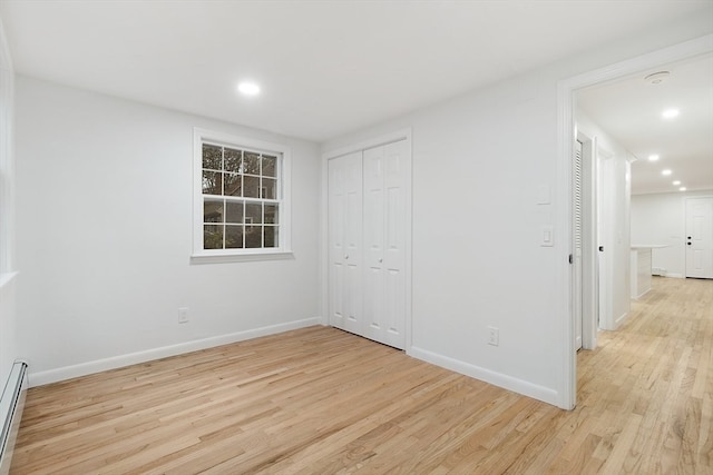 empty room featuring light hardwood / wood-style floors and baseboard heating