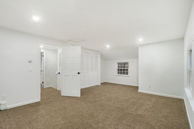 carpeted spare room featuring lofted ceiling