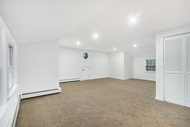 unfurnished room with light colored carpet and a baseboard heating unit