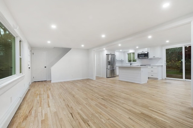 unfurnished living room featuring light hardwood / wood-style flooring and a wealth of natural light